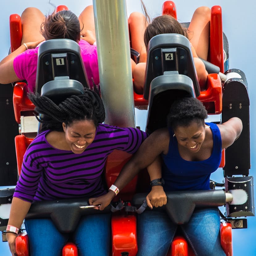 Two women smiling on the Hot Seat thrill ride.